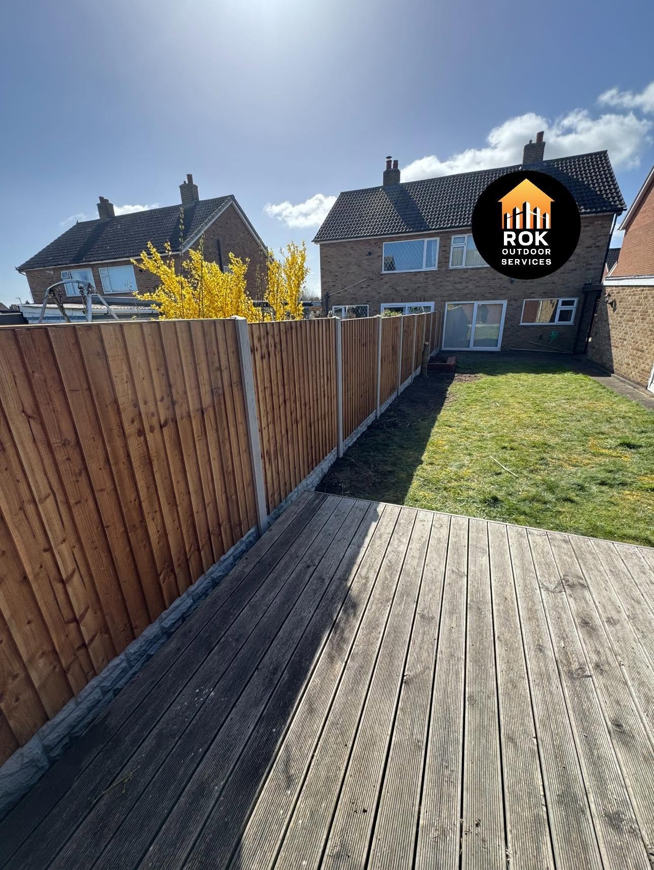 Garden fencing beside a decked area and lawn